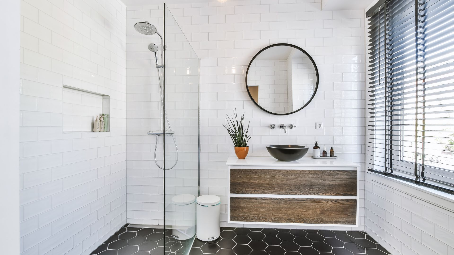 A bathroom with a sink, mirror, and shower