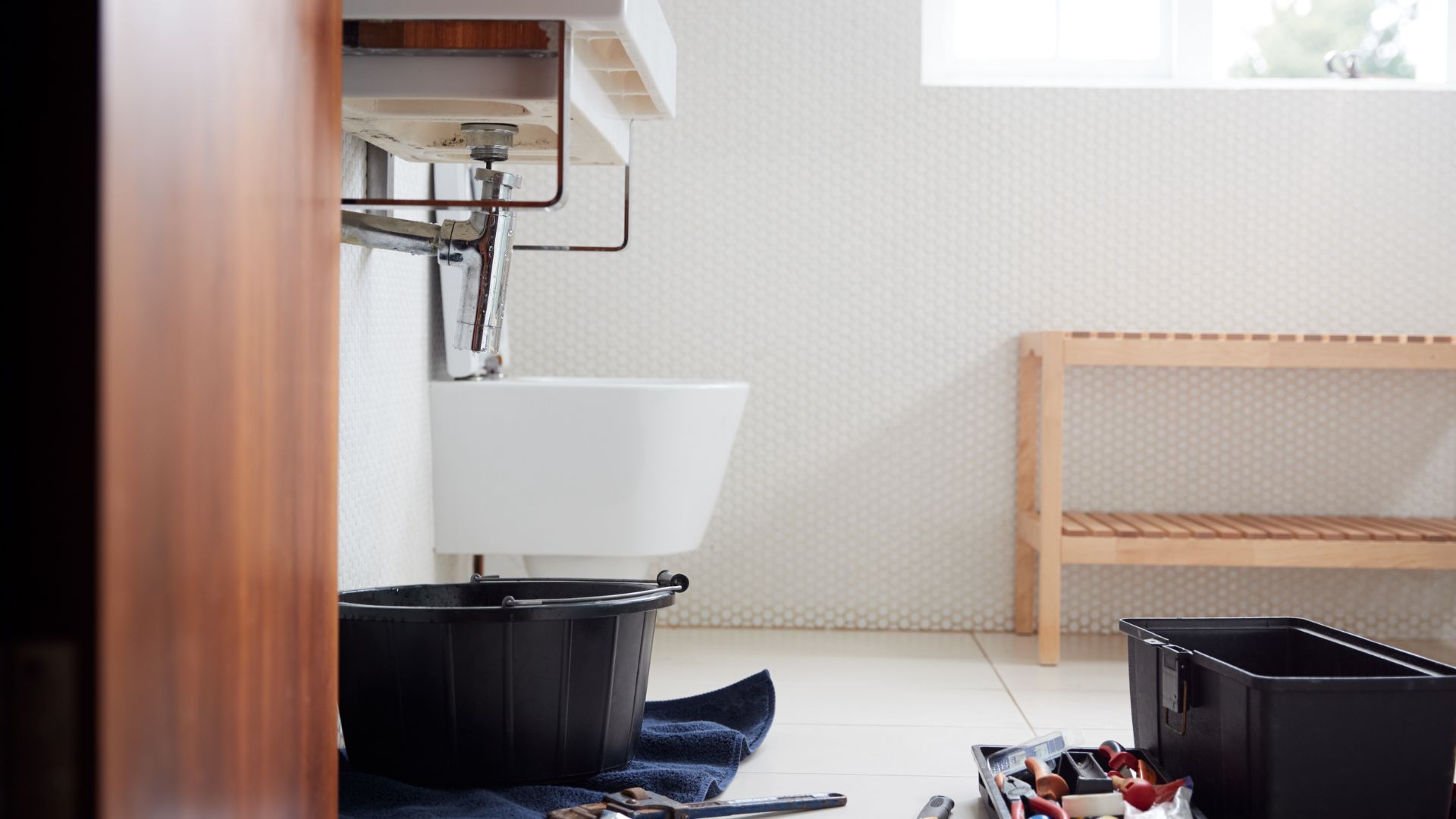 A bathroom with a toilet, sink, and other items on the floor