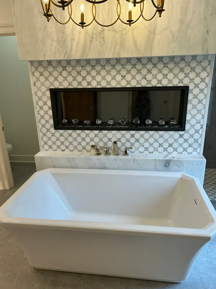 A white bath tub sitting under a chandelier