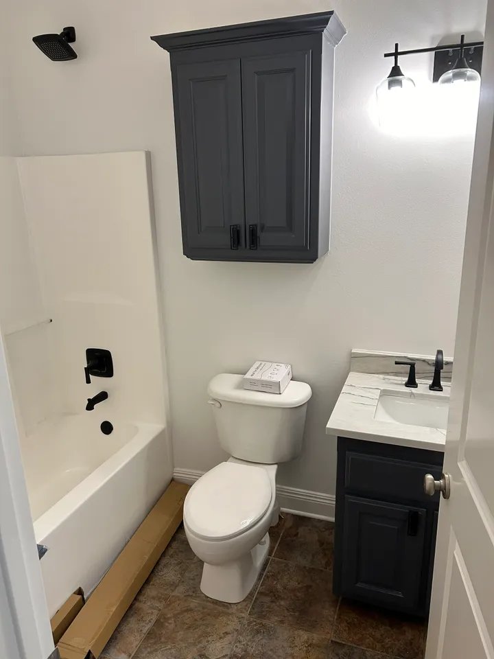 A white toilet sitting next to a bath tub